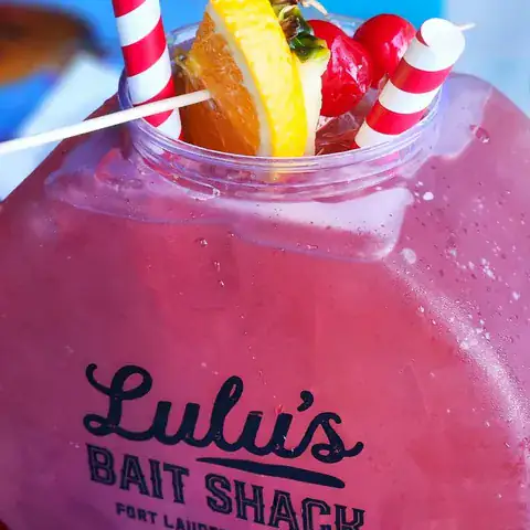 Large pink World Famous Fish Bowl cocktail in a Lulu's Bait Shack souvenir container