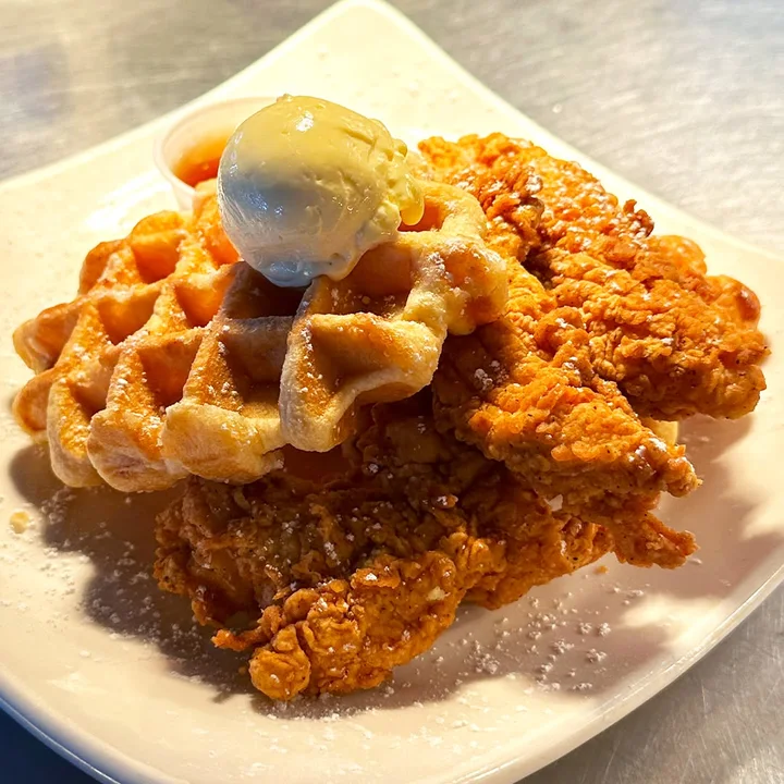 Chicken tenders served over a Belgian waffle with whipped butter.